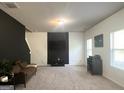Bright living room with neutral carpet, dark accent wall, and ample natural light from the large windows at 2282 Joplin St, Jonesboro, GA 30236