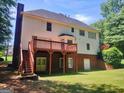 Spacious backyard featuring a wooden deck, stairs, and basement access doors at 308 Bell Isle, Mcdonough, GA 30252