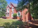 This home features a well-maintained lawn, brick exterior, and mature trees at 308 Bell Isle, Mcdonough, GA 30252