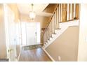 Inviting foyer with hardwood floors, staircase, and stylish lighting fixture at 235 Woodstream Way, Fayetteville, GA 30214