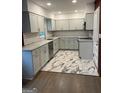Modern kitchen with white cabinetry, granite countertops, stainless appliances, and decorative tile flooring at 1858 Sahara Se Dr, Atlanta, GA 30316