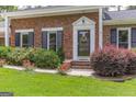 Close up view of the home's brick facade with decorative landscaping at 2118 Allaire Ne Ln, Atlanta, GA 30345