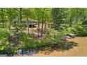 Aerial view of property with home, dock, and wooded area surrounding the pond at 679 Bo Bo Banks Rd, Grantville, GA 30220