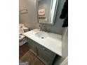 Bathroom with marble countertop, grey accent walls, decorative mirror, and toilet at 223 Rivers Rd, Fayetteville, GA 30214