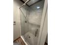 Modern glass-enclosed shower with white tile and updated fixtures, plus tile flooring at 223 Rivers Rd, Fayetteville, GA 30214