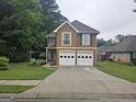 Inviting two-story home featuring a two-car garage, well-kept lawn, and charming curb appeal at 320 Weatherly Drive, Fayetteville, GA 30214