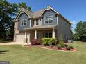 Charming two-story home with landscaped front yard, brick and siding and a two-car garage at 101 Elkins Blvd, Locust Grove, GA 30248