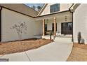 Inviting front porch with wooden columns, double doors, and neat landscaping, perfect for relaxing at 135 Wet Wood Dr # 12, Fairburn, GA 30213