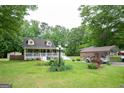 Two-story home with a big yard, complemented by a carport and decorative features at 3777 Edward Rd, Rex, GA 30273