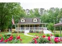 Inviting two-story home with covered porch, landscaped garden, and American flag at 3777 Edward Rd, Rex, GA 30273