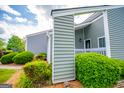 A quaint front porch is beautifully landscaped with vibrant green bushes at 325 Berry Ct, Villa Rica, GA 30180