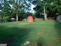 View of the backyard and a small red barn in the corner at 5243 Eubanks Dr, Lake City, GA 30260