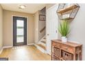 Inviting entryway with wood-look flooring, a front door, and staircase with wood treads and white risers at 10 Queens Ct, Sharpsburg, GA 30277