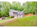 Charming two-story home surrounded by mature trees and lush landscaping on a sloped lot at 10 Queens Ct, Sharpsburg, GA 30277