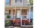 A close-up of the home's front porch, featuring stone accents, a decorative window and charming decor at 190 Princeton Way, Covington, GA 30016