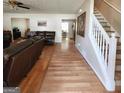 Spacious living room featuring hardwood floors, a staircase, and comfortable leather furniture at 190 Princeton Way, Covington, GA 30016