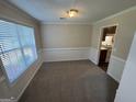 Dining area with neutral paint, plush carpet, and natural light from a window at 4551 Mitchells Meadow Ln, Ellenwood, GA 30294