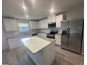 Kitchen features white cabinets, island, granite countertops, and stainless steel appliances at 11045 Shadow Creek Ter # 65, Hampton, GA 30228