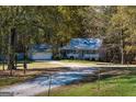 Exterior view of a charming home with a detached garage with fall foliage at 335 Gum Creek Rd, Roopville, GA 30170