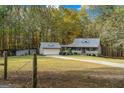Exterior view of a charming home with a detached garage surrounded by a lawn and wooded area at 335 Gum Creek Rd, Roopville, GA 30170