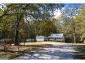 Exterior view of a home featuring a front porch, detached garage, and a wooded area at 335 Gum Creek Rd, Roopville, GA 30170
