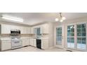 Well-lit kitchen featuring white cabinets, stainless steel appliances, and tile floors at 5523 Forest Dr, Loganville, GA 30052
