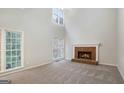 Bright living room with a brick fireplace, large windows, and neutral carpeting at 5523 Forest Dr, Loganville, GA 30052