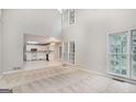 Open-concept living room showing kitchen with white cabinets, and large windows at 5523 Forest Dr, Loganville, GA 30052