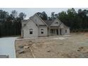 Charming new construction home featuring a stone facade, modern design, and manicured landscaping at 49 Durham Estates Dr, Sharpsburg, GA 30277