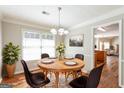 Elegant dining room featuring hardwood floors, a chandelier, and a view into the kitchen at 1416 Emerald Pine Ct, Lawrenceville, GA 30043