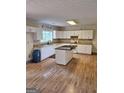 Bright kitchen with white cabinets, granite countertops, a central island, and modern appliances at 191 Lagrange Street, Grantville, GA 30220
