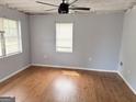 Bedroom with hardwood floors, two windows, light gray walls, and a ceiling fan at 305 Anderson Cir, Covington, GA 30016