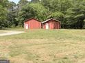 Exterior shot of two red storage buildings in a grassy backyard at 305 Anderson Cir, Covington, GA 30016