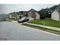 View of the side of this two-story home, showing the lawn and the private driveway that leads to an attached garage at 7644 Wrotham Cir, South Fulton, GA 30349