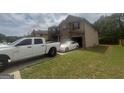 Side view of a two-story home with a driveway, lawn, and attached garage at 7644 Wrotham Cir, South Fulton, GA 30349