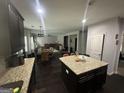 Open-concept kitchen with an island, dark wood cabinets, granite countertops, and stainless steel appliances at 7644 Wrotham Cir, South Fulton, GA 30349