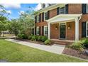 Inviting front entrance with a brick facade, black door, white trim, manicured lawn, and mature landscaping at 171 Ponderosa Drive, Fayetteville, GA 30214