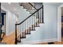 Classic staircase with white spindles, a black handrail, and carpeted steps leading to the upper level at 171 Ponderosa Drive, Fayetteville, GA 30214