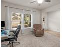 Well-lit living room featuring a comfortable chair, neutral carpet, and ample natural light at 168 Warbler Way, Mcdonough, GA 30253