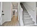 A bright foyer with hardwood floors, stairs, white railings, and a view into the kitchen at 122 Claxton Ct, Jonesboro, GA 30238