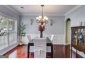 Elegant dining room with a decorative chandelier, wainscoting, and rich hardwood floors at 7115 Secret Rose, Douglasville, GA 30134