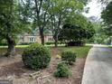 A traditional brick home with a lush front yard, mature trees, and a long driveway at 2451 Old Salem Se Cir, Conyers, GA 30013