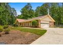 Exterior showcasing the attached two-car garage and mature trees around the property at 200 Whitney Way, Fayetteville, GA 30214