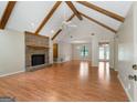 Open living room featuring vaulted ceilings, exposed wood beams, and a brick fireplace at 200 Whitney Way, Fayetteville, GA 30214