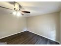 This bedroom features neutral paint, modern ceiling fan, and updated hardwood flooring at 5219 Maple Valley Sw Rd, Mableton, GA 30126