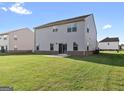 A well-maintained backyard featuring lush green grass and a neutral-colored house with a sliding glass door at 838 Maduro Way, Mcdonough, GA 30253