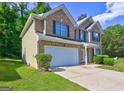 Two-story brick home with attached garage, well-kept lawn, and mature landscaping at 325 Espana St, South Fulton, GA 30349