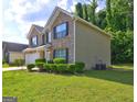 Brick home with a well-maintained lawn and landscaped shrubbery at 325 Espana St, South Fulton, GA 30349