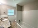 Bright bathroom with a tub/shower combo and granite countertop at 4313 Executive Dr, Stone Mountain, GA 30083