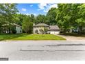 Two-story home with a large lawn, mature trees, and a two-car garage at 224 Claridge Curv, Peachtree City, GA 30269